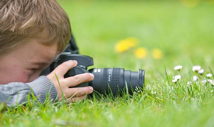 Young boy, nine years old, already practicing with an SLR shooting pictures of nature.