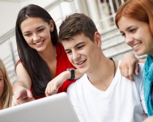 Group of university students using laptop outdoors